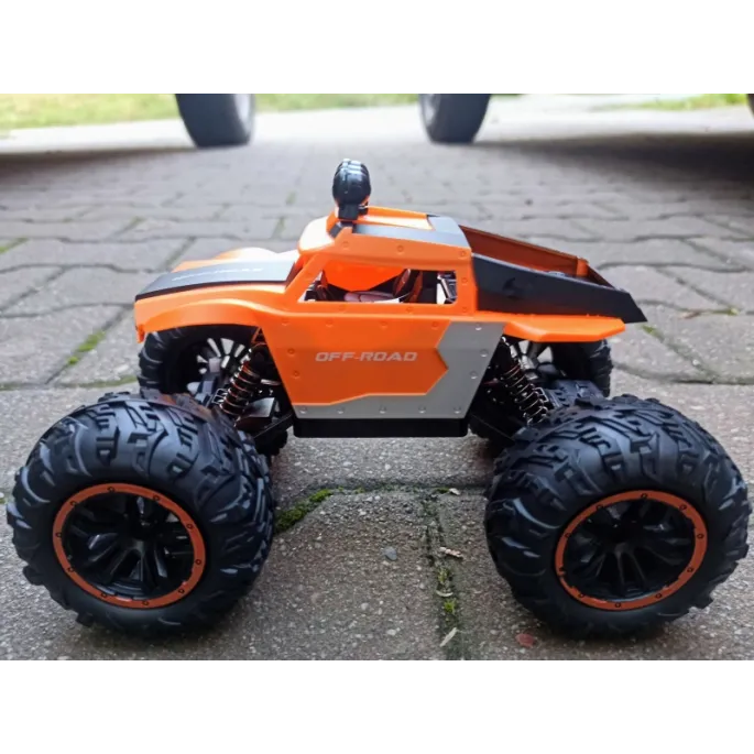 Terrenówy samochód RC z dużymi gumowymi oponami.