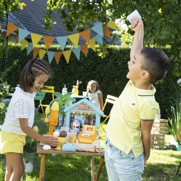 Dwie dziewczynki bawią się przy barze plażowym