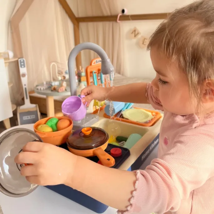 Mały kucharz przy zlewozmywaku
