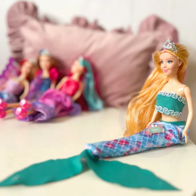 Zestaw lalek z różnymi akcesoriami i ubrankami.