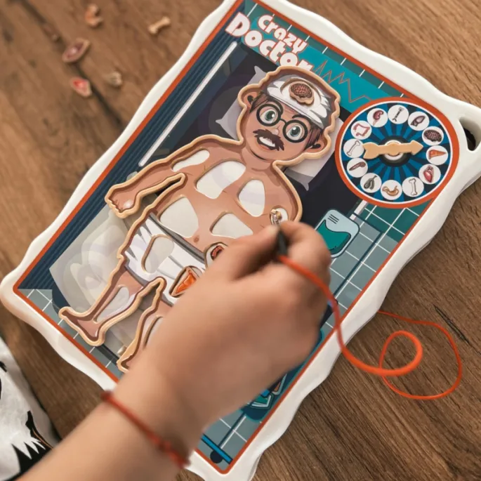 Zestaw zawiera planszę, pęsetę i narządy do gry.