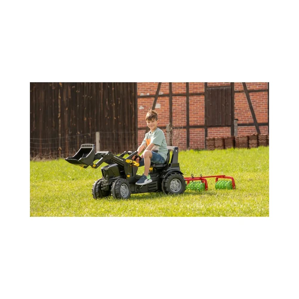 Dzieci bawiące się brona Rolly Toys w ogrodzie