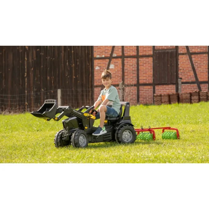 Dzieci bawiące się brona Rolly Toys w ogrodzie