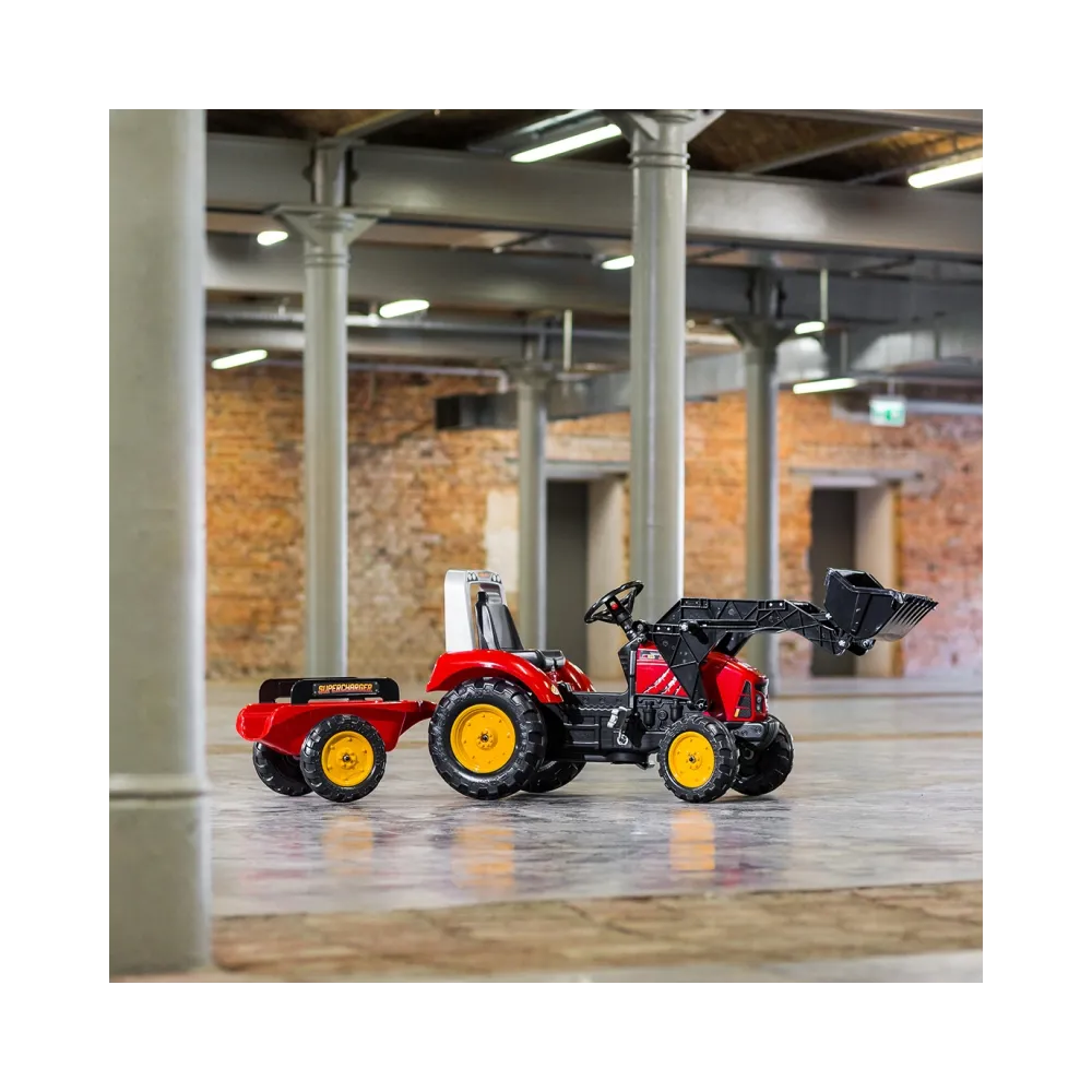 Dzieci bawiące się traktorem i przyczepą FALK na podwórku