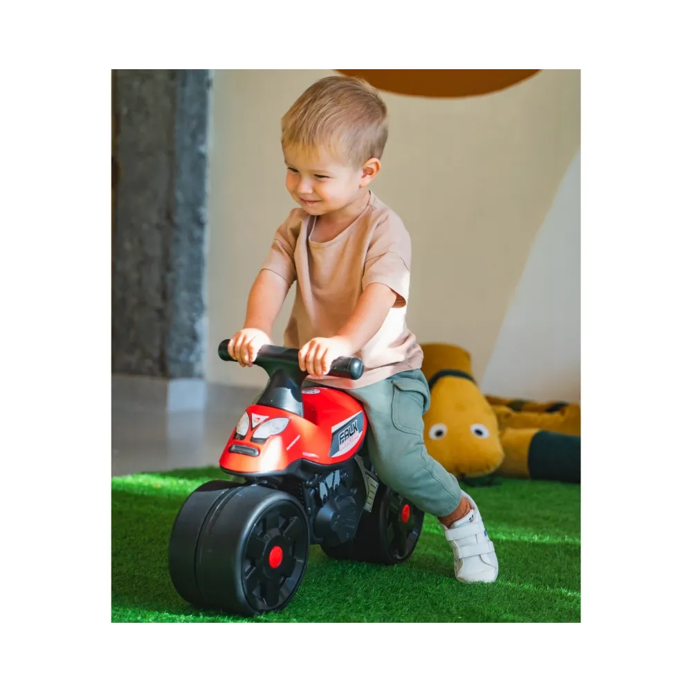 Dziecko bawi się jeździkiem Racing od FALK w ogrodzie