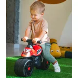 Dziecko bawi się jeździkiem Racing od FALK w ogrodzie