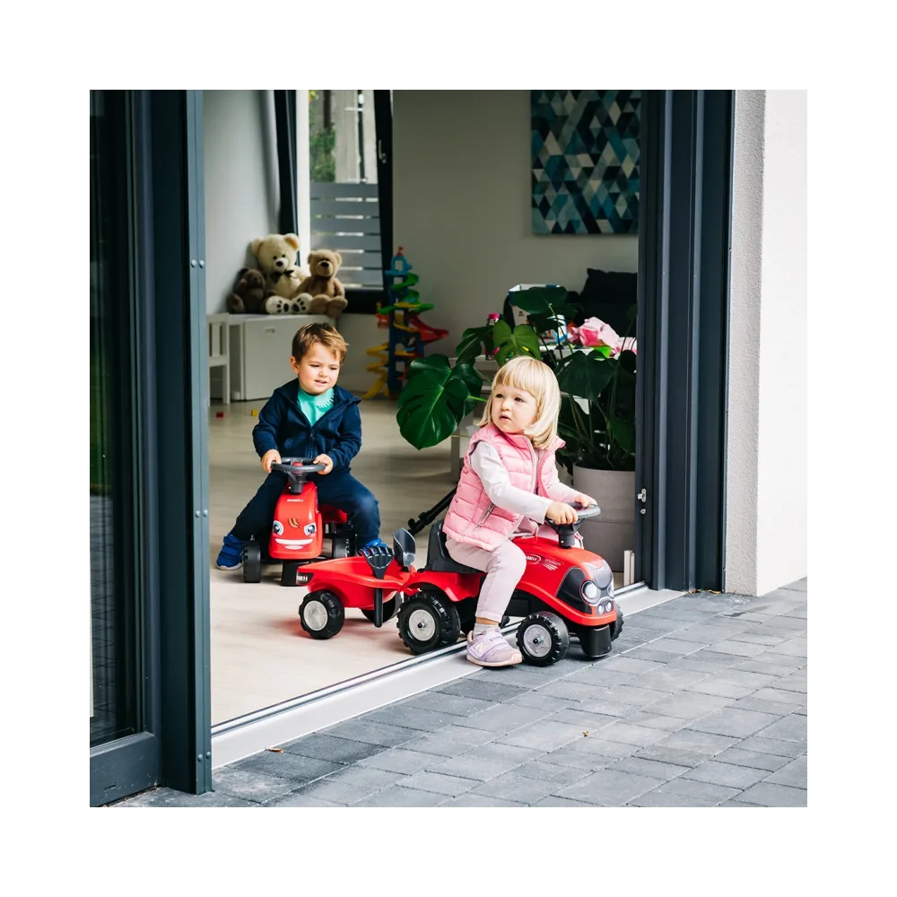 Dzieci bawiące się traktorkiem i przyczepką