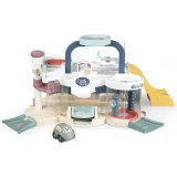 Dzieci bawią się w garażu SMOBY z samochodzikiem.