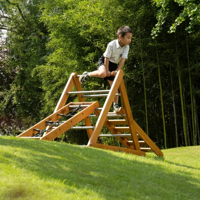 Drewniany zestaw montessori do wspinaczki w ogrodzie.