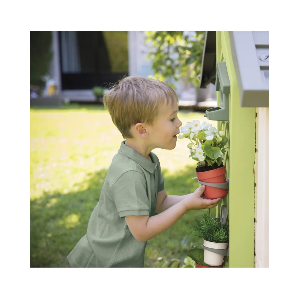Dzieci bawią się w ogrodników w domku Smoby