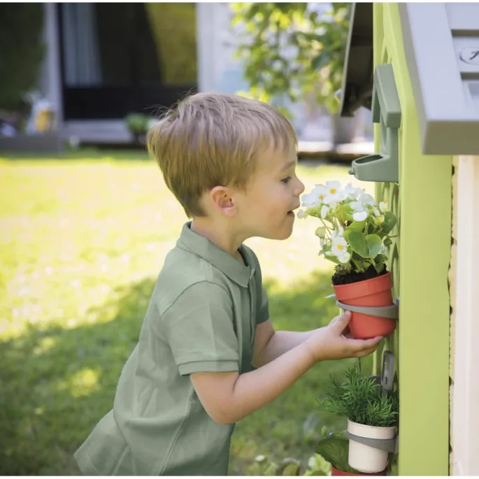 Dzieci bawią się w ogrodników w domku Smoby