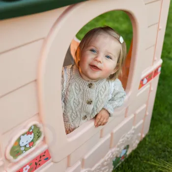 Dzieci bawią się w domku Hello Kitty na świeżym powietrzu.