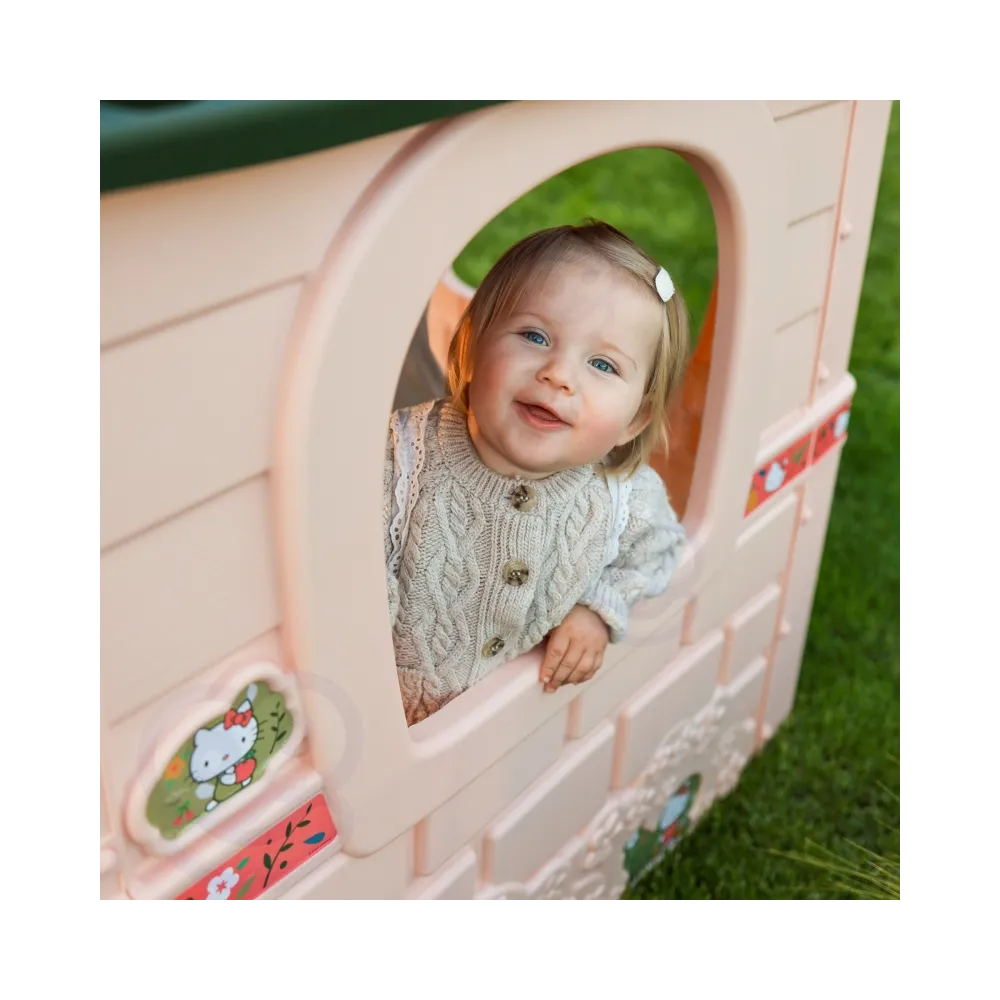 Dzieci bawią się w domku Hello Kitty na świeżym powietrzu.