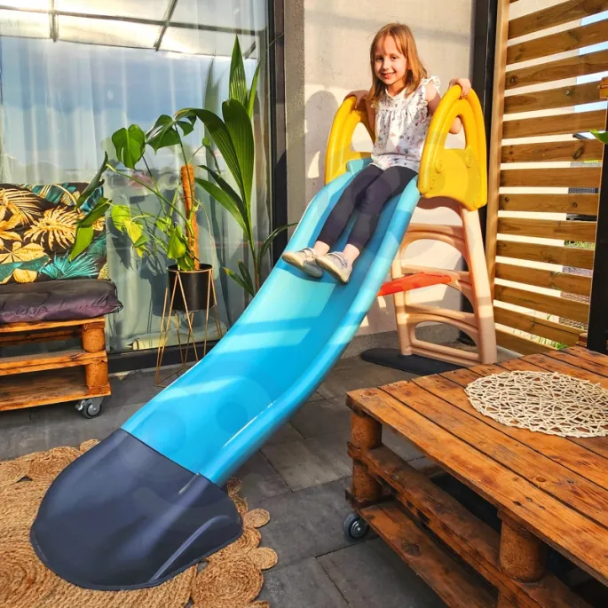 Dzieci bawią się na zjeżdżalni Feber w ogrodzie