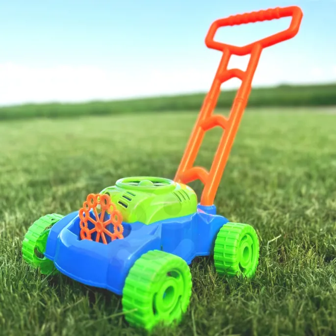 Dzieci bawiące się kosiarką na świeżym powietrzu