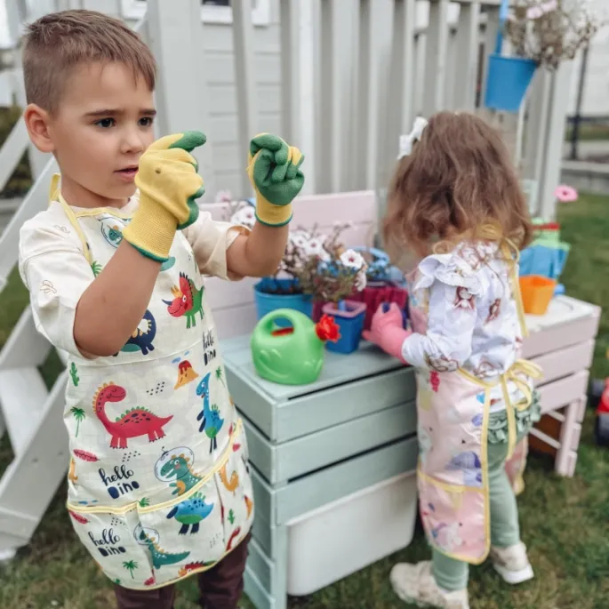 Dziecko używa konewki do podlewania roślin