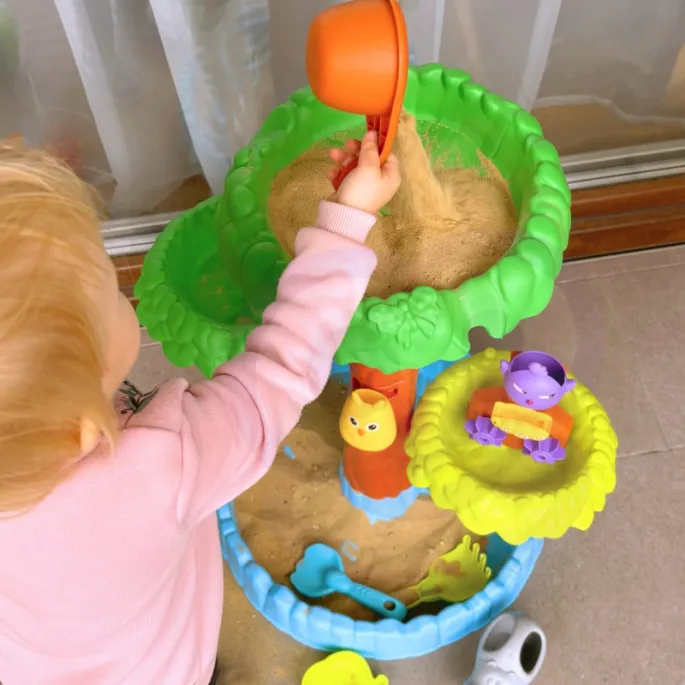 Dzieci bawiące się na stoliku wodnym w ogrodzie