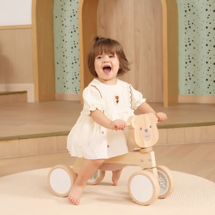 Miś brunatny na drewnianym jeździku dla dzieci