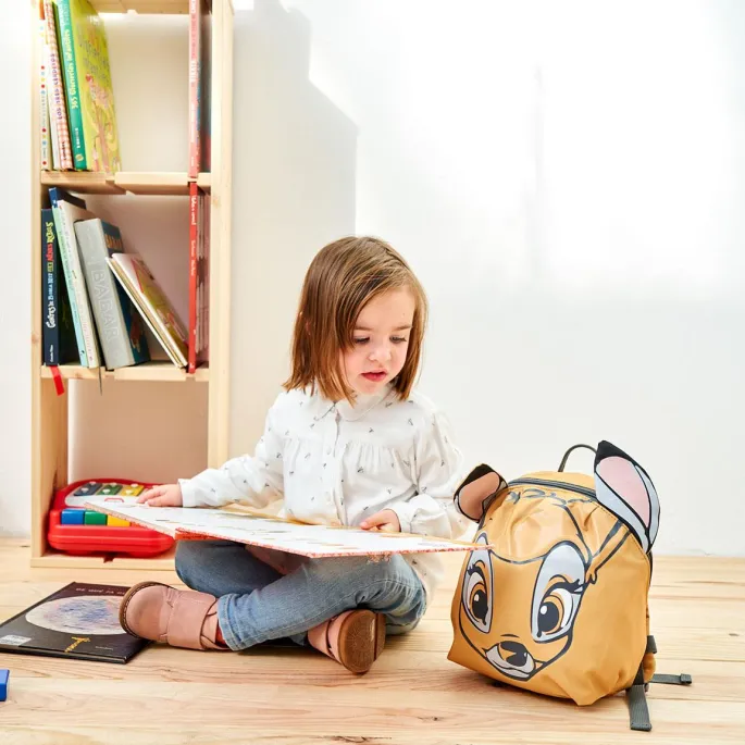 Kolorowy plecak Disney Bambi na tle dziecięcych gadżetów