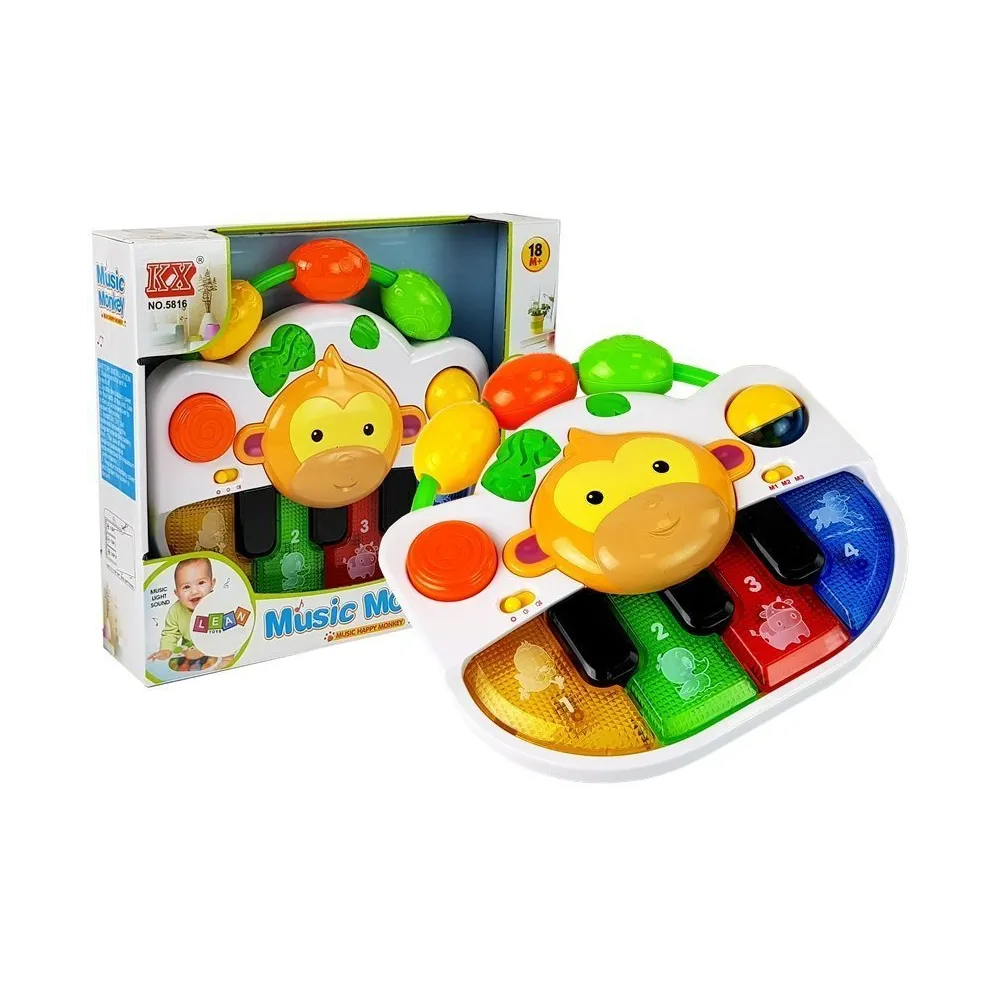 Kolorowe pianinko z małpką dla niemowlaka na białym tle