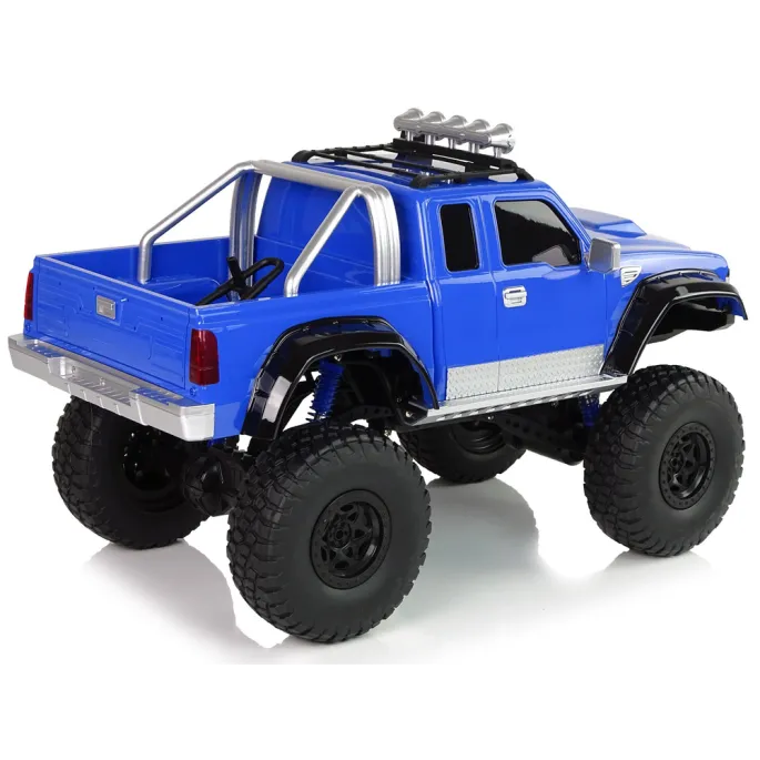 Niebieskie auto R/C 4x4 podczas jazdy po nierównym terenie