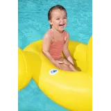 Dziecko siedzi na dmuchanej kaczce w basenie latem