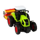 Widok z boku na zielony traktor z przyczepioną prasą