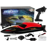 Czerwona motorówka R/C podczas szybkiej jazdy po jeziorze