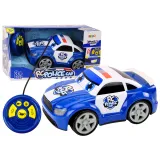 Kreskówkowe autko policyjne z pilotem na tle białym