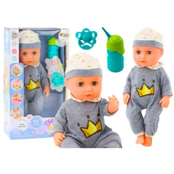 Lalka bobas w szarej piżamce z butelką i smoczkiem na białym tle