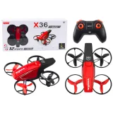 Czerwony dron RC X36 SYMA w locie z pilotem widoczny z boku