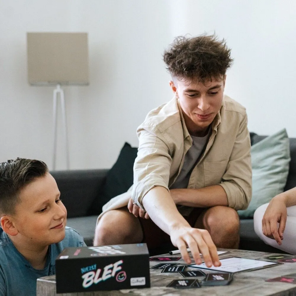 Gra planszowa Niezły Blef Trefl podczas rozgrywki w grupie znajomych