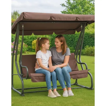 Praktyczna huśtawka bujana z daszkiem i poduszkami ustawiona na patio