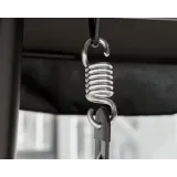 Stalowa huśtawka z czterema miękkimi poduszkami w ogrodzie