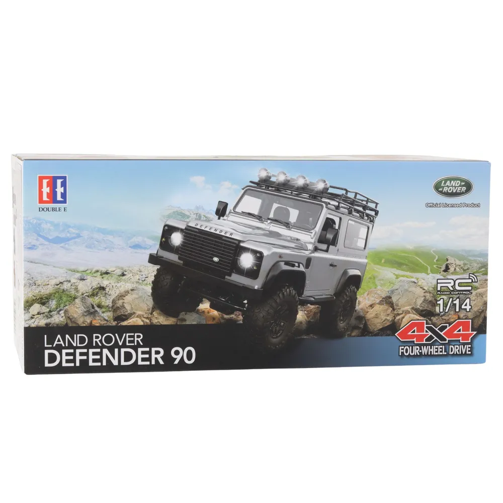 Czerwony samochód terenowy RC Land Rover Defender 90 jadący po skałach
