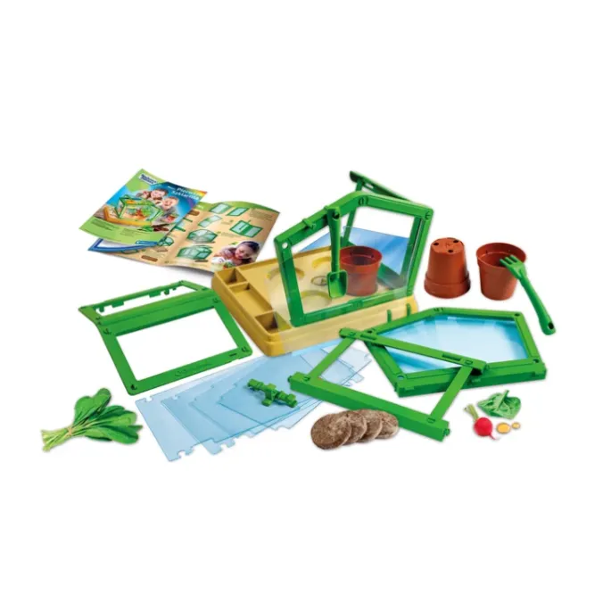 Dziecko bawiące się szklarnią edukacyjną i sadzące rośliny
