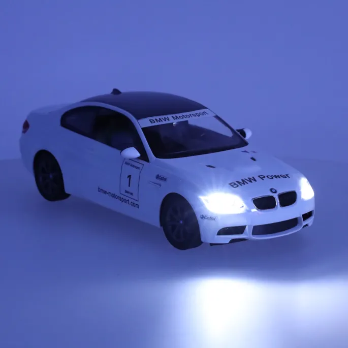 Biały model RC BMW M3 ustawiony obok kontrolera