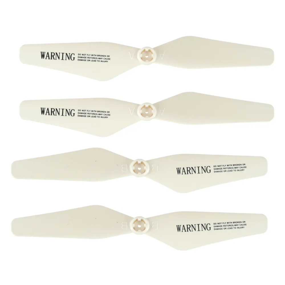 Biały dron SYMA Z3 startuje z powierzchni trawy na zewnątrz