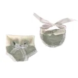 Widok lalki siedzącej w jasnozielonym zestawie ubranek