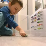 Walizka na samochodziki ustawiona na dziecięcej półce