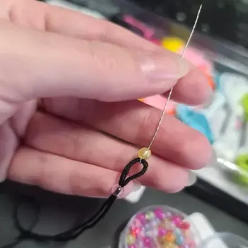 słoiczki z koralikami w różnych kolorach rozłożone przy akcesoriach