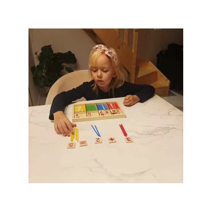 dziecięca ręka sięgająca po patyczek do nauki liczenia