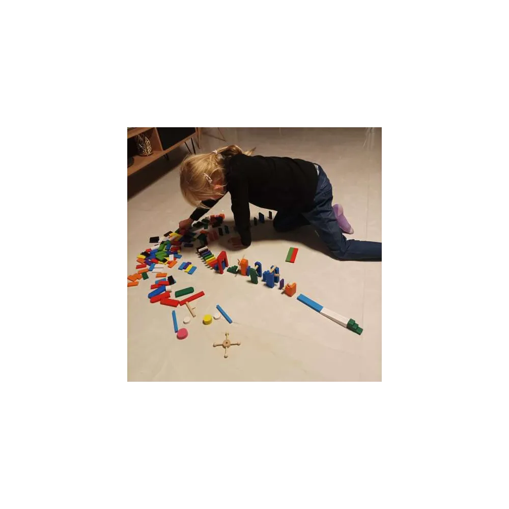 ręka dziecka ustawiająca kolorowy klocek podczas zabawy domino