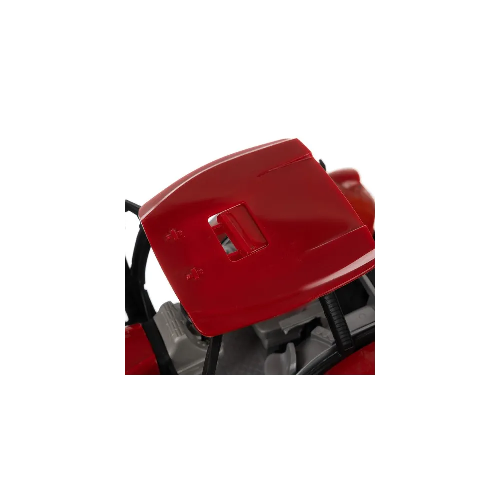 czerwony traktor z przyczepą na tle podwórza