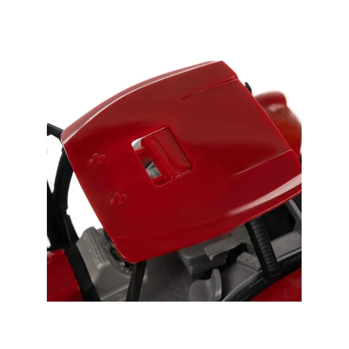 czerwony traktor z przyczepą na tle podwórza