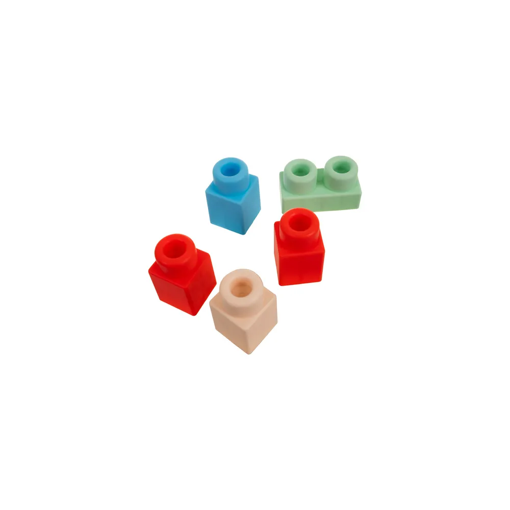 dziecięca ręka chwytająca klocki sensoryczne o zaokrąglonych krawędziach