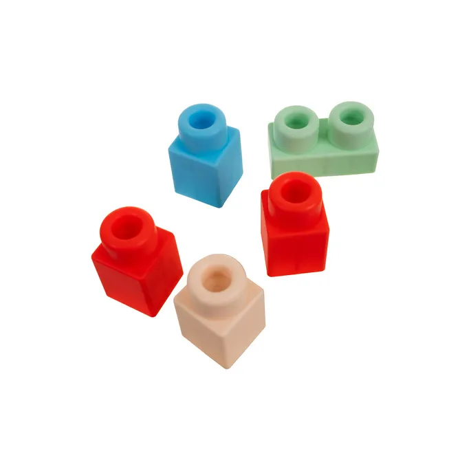 dziecięca ręka chwytająca klocki sensoryczne o zaokrąglonych krawędziach