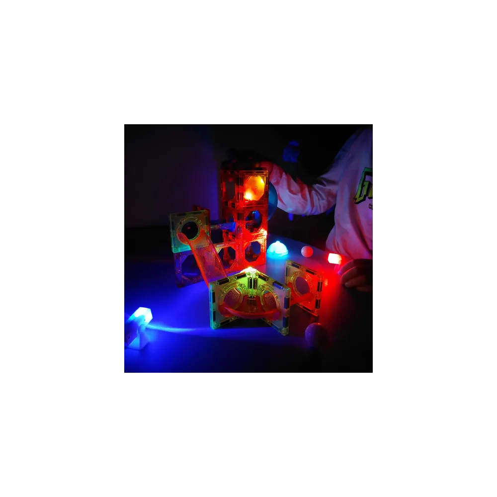 dziecko budujące tor kulkowy z magnetycznych paneli