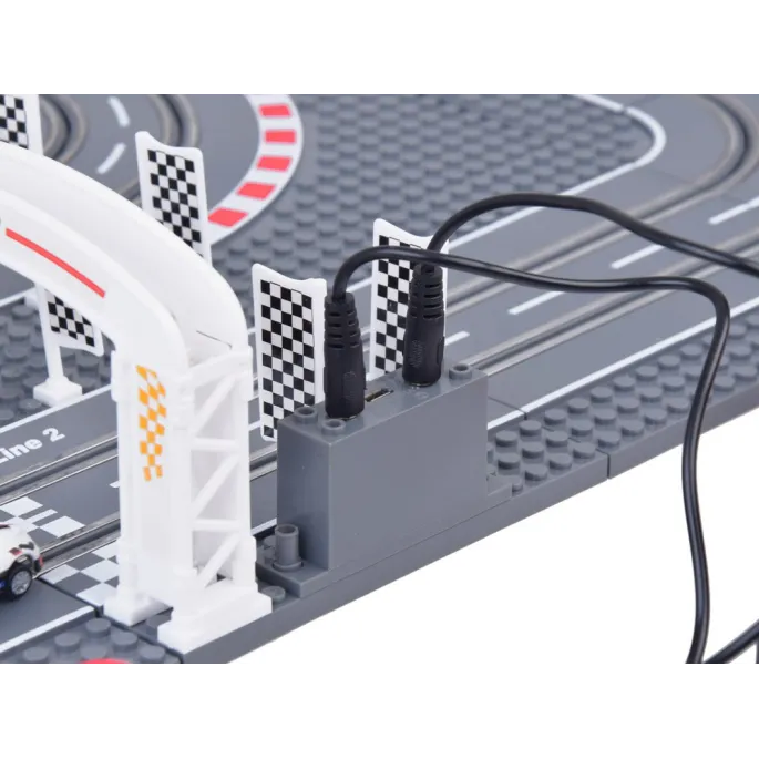 dwa samochodziki podczas wyścigu na zbudowanej trasie z klocków