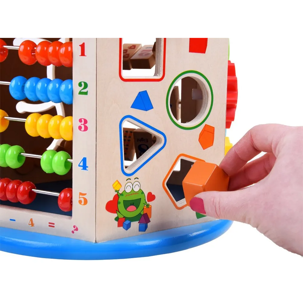 Kompaktowa kostka edukacyjna ustawiona na podłodze w otoczeniu kolorowych klocków